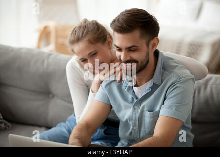 Happy couple spending time together at home, using laptop Stock Photo