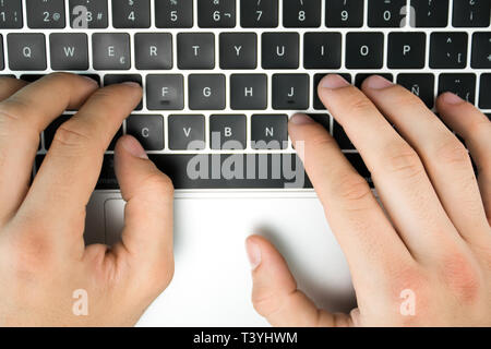 Close-up of the hands of a business person typing on his computer. Keyboard with black keys. Stock Photo