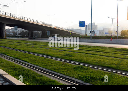 Izmir, Turkey - November 10, 2018: Tram rails with grass. And we see a highway bridge. Stock Photo