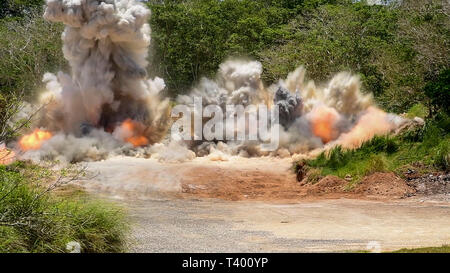 190409-N-LN093-1076 ANDERSON AIR FORCE BASE, Guam (April 9, 2019) Debris  from an explosion fills the air during joint quarry operations conducted by Sailors  assigned to Naval Mobile Construction Battalion 133 (NMCB) and Airmen assigned to  554th Red Horse Squadron at Anderson Air Force Base’s quarry. NMCB conducted the  demolition in order to maintain proficiency in blast operations that support construction  and repair efforts in the region. NMCB-133, provides expeditionary construction and  engineering capabilities that includes maintenance and operation of expeditionary bases  and facilit Stock Photo