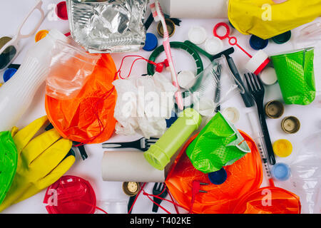 Plastic pollution concept. Be plastic free. Broken single-use colorful different plates, forks, cups, bottle, straw, toothbrush, lids, foil and other  Stock Photo