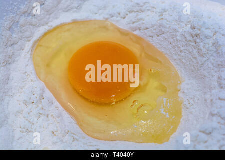 Egg yolks and egg whites on flour while baking Stock Photo