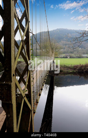 Small suspension bridge over river with hills in background Stock Photo