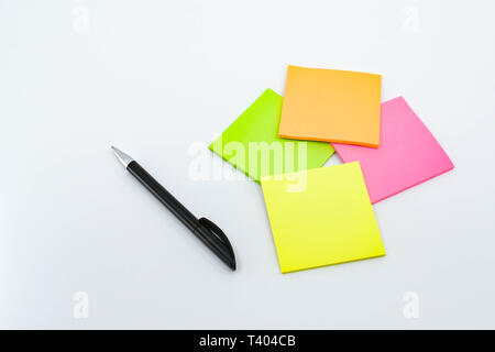Pen and note pads in day glo colors isolated against a plain white background. Stock Photo
