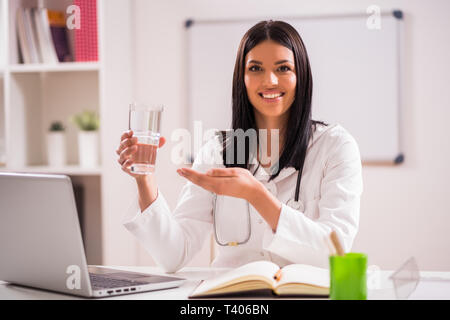 Young doctor is talking about importance of water for heart health. Stock Photo