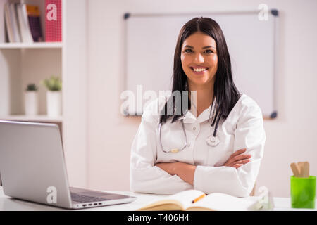 Portrait of young happy doctor in her office. Stock Photo