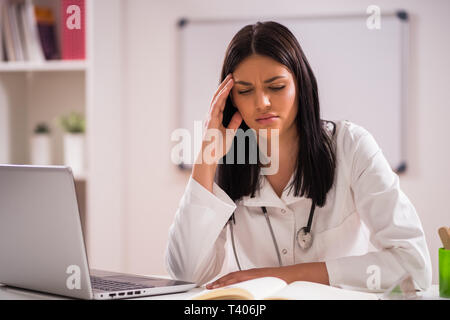 Portrait of tired doctor in her office. Stock Photo