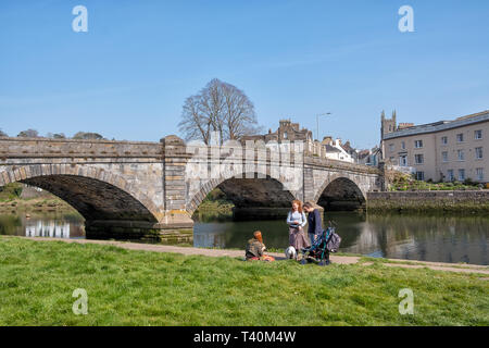 Totnes Bridge is the nearest bridge to the sea, over the River Dart, and is a road bridge built in 1826–28 by Charles Fowler. There are three people. Stock Photo