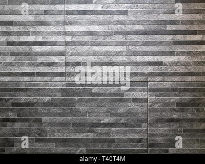abstract pattern wall made of grey granite stones thin blocks bricks Stock Photo
