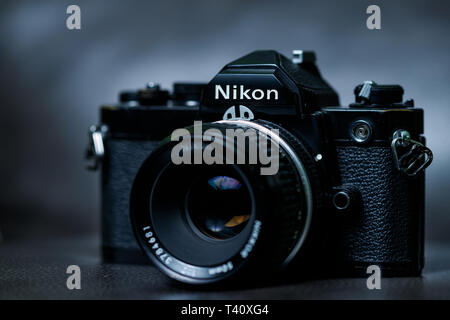 An old Nikon Single Lens Reflex (SLR) 35 mm film camera along with a 50mm portrait lens Stock Photo
