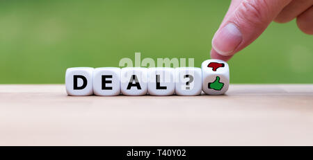 Thumbs up for having a good deal. Hand turns a dice and changes the thumbs down symbol to a thumbs up symbol. Stock Photo