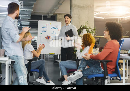 Young millennial team analyzing information on graphs and charts Stock Photo