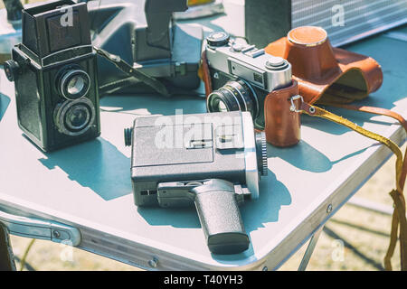 Old vintage film photographic equipment on the table. Cameras and Camcorder. Selective focus