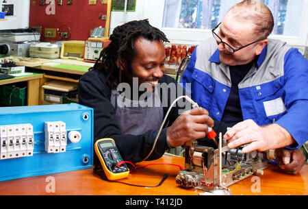 Teamwork, Two Electricians working together Stock Photo