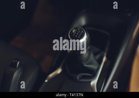 Close up view of a gear lever shift. Manual gearbox. Car interior details. Car transmission. Soft lighting. Abstract view. Stock Photo