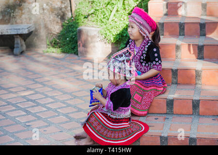 Chiang Mai, Thailand - November 06, 2015: Two Thai children in traditional clothes on the stairs to the Golden Temple of Chiang Mai. Stock Photo