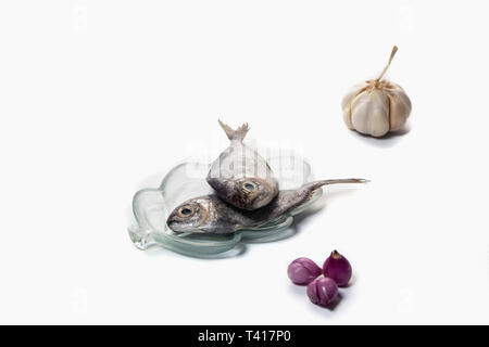 Two fish on a pate with garlic and shallots Stock Photo