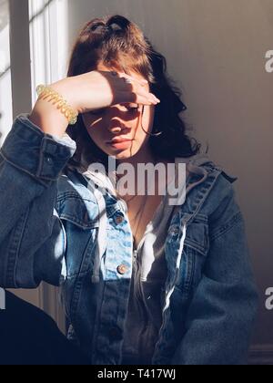 Portrait of a teenage girl shielding her eyes Stock Photo
