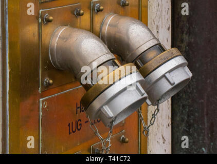 twin brass fire hydrant coupling on exterior of building wall in Berlin germany Stock Photo