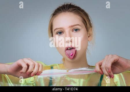 Showing her tongue. Extravagant blue-eyed young model showing her tongue with pink pill on it Stock Photo