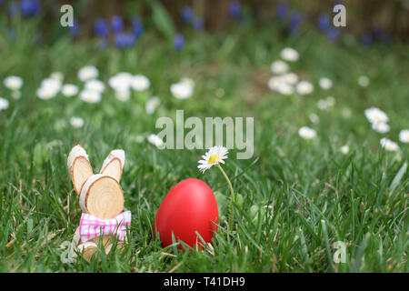 Easter hunt - red egg and wooden bunny in a grass Stock Photo