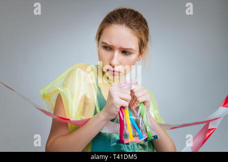 Little plastic bag. Fair-haired young professional model holding little plastic bag with razors inside Stock Photo