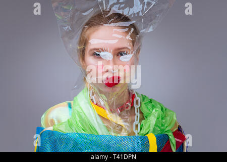 With red lips. Young model with red lips having plastic bag on her face posing for ecology photo shoot Stock Photo