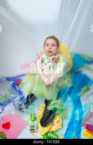 For ecology movement. Young fair-haired model sitting near plastic sheet while posing for ecology movement Stock Photo