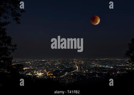 Lunar eclipse over Chiang Mai city. Blood Moon in the lunar eclipse and also a Blue Moon and super moon called Super Blue Blood Moon Stock Photo