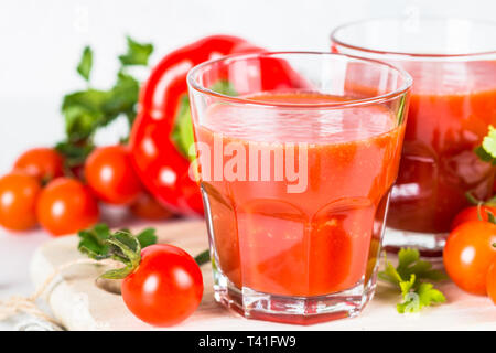 Tomato vegetable juice in glass on white. Stock Photo
