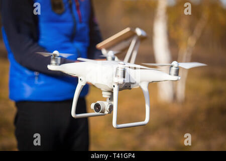 Man operating drone flying by remote control in the park Stock Photo