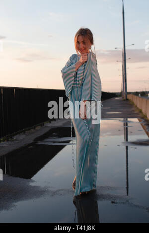 the girl on the bridge in full growth is smiling Stock Photo