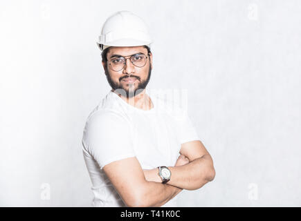 Young builder engineer with glasses and a white protective helmet Stock Photo