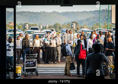 Kisumu airport, Kenya - March 6, 2019 - unofficial taxi drivers wait for clients across the road from airport; they are not allowed to come closer Stock Photo