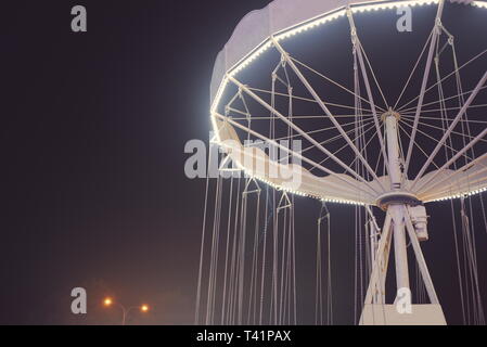 Floodlit White Chain Merry-go-round at Night Closeup Stock Photo