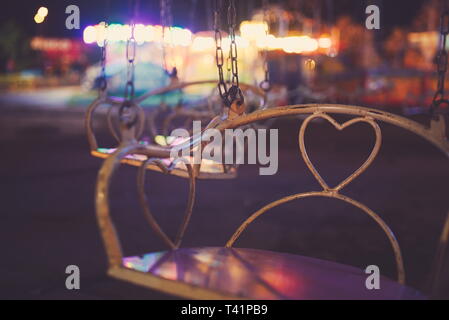 Chain Carousel Closeup with Town Fair Lights at Night Stock Photo
