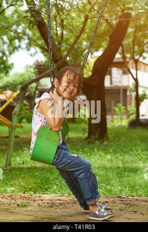 Happy smiling asian girl in green sunny park background Stock Photo