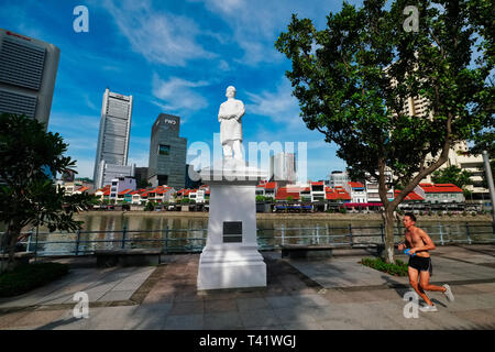 A jogger passes the statue of Singapore pioneer Boat Quay, Singapore, the buildings of the financial district in the background Stock Photo