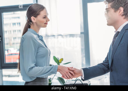 attractive woman shaking hands with recruiter in glasses Stock Photo
