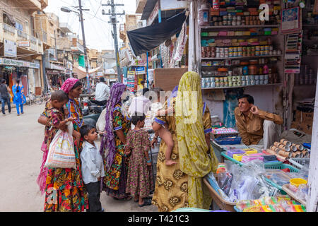 Group of rajasthani women and children in a street shop in Jaisalmer market, Rajasthan, India Stock Photo