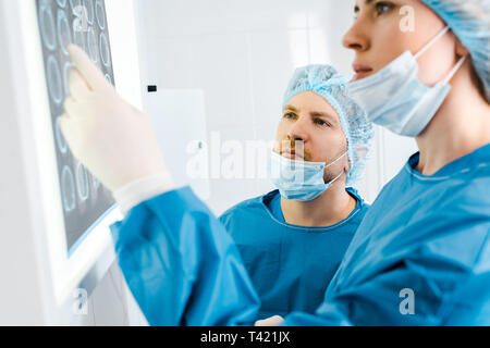 selective focus of doctors in uniforms looking at x-ray in clinic Stock Photo