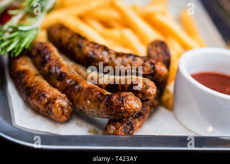 Close up meal with sausages, french fries, chili pepper and jalapeno Stock Photo
