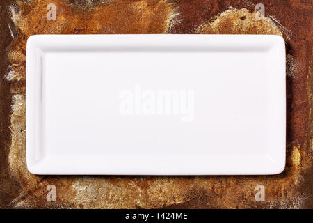 Empty white cornered plate on rusted metal background, top view Stock Photo