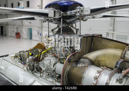 Helicopter gas-turbine engine with the cowling opened for maintenance in hangar Stock Photo