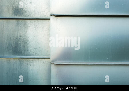 Photo closeup shiny steel aluminum fragment of protective facade structure made of metal plates sheets horizontally assembled textured background Stock Photo