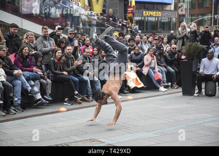 Crowds are entertained in Times Square by a troupe of talented breakdancers showing their strength and skills  at the sport/ performing arts performance. Stock Photo