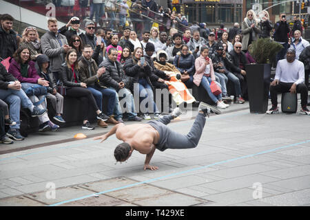 Crowds are entertained in Times Square by a troupe of talented breakdancers showing their strength and skills  at the sport/ performing arts performance. Stock Photo