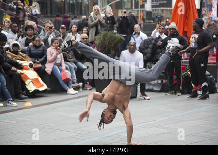 Crowds are entertained in Times Square by a troupe of talented breakdancers showing their strength and skills  at the sport/ performing arts performance. Stock Photo