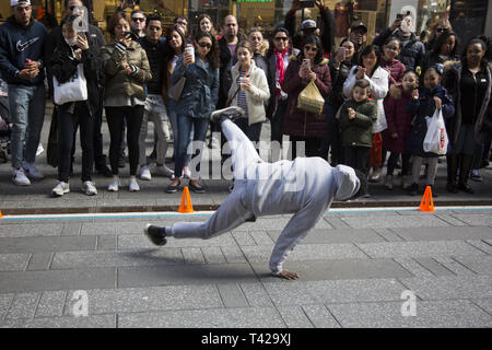 Crowds are entertained in Times Square by a troupe of talented breakdancers showing their strength and skills  at the sport/ performing arts performance. Stock Photo