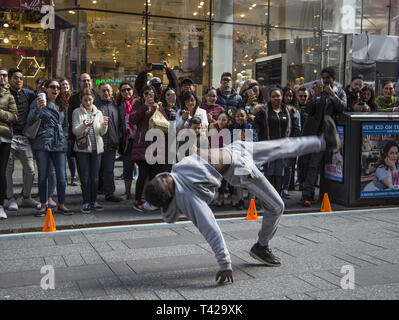 Crowds are entertained in Times Square by a troupe of talented breakdancers showing their strength and skills  at the sport/ performing arts performance. Stock Photo